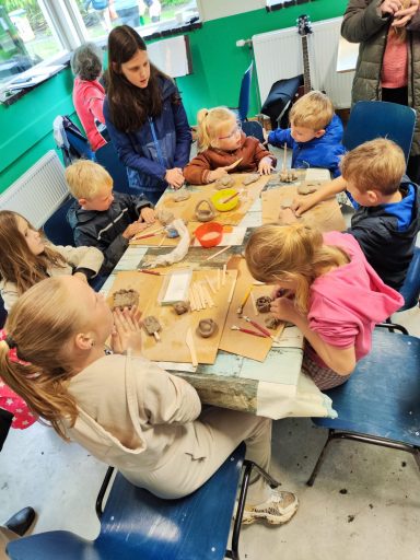 Groep kinderen werkt samen aan een knutselproject aan een tafel.